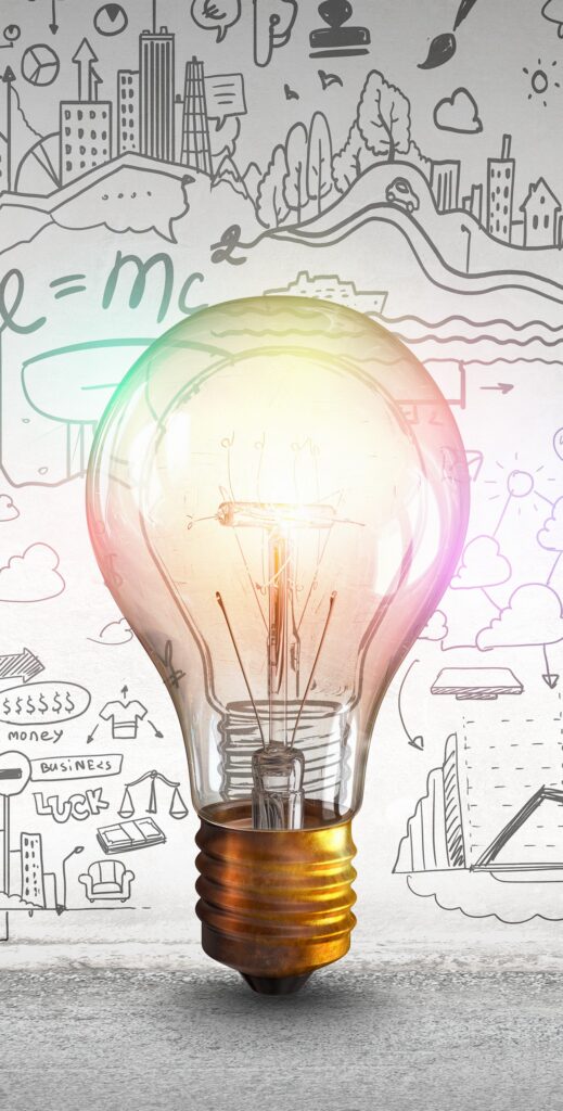 A glowing light bulb in front of a wall with hand-drawn sketches of graphs, buildings, formulas, and creative ideas, symbolizing innovation and inspiration—much like the spark that comes from discovering new insights when you know why set up Google Alerts.