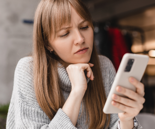 woman looking at cellphone stressed