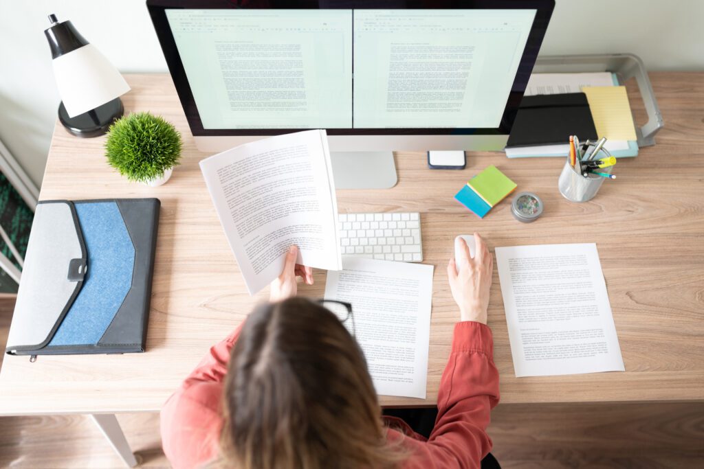 Overhead view of person writing content on computer