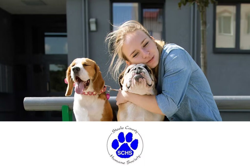 Steele County humane society girl  show ours support by hugging dog